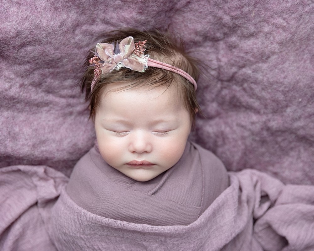 Baby wrapped in dusky pink during newborn mini photography session