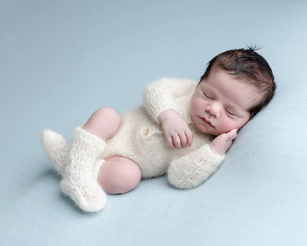 Newborn boy sleeping in cute outfit on blue blanket, Bridgwater Studio