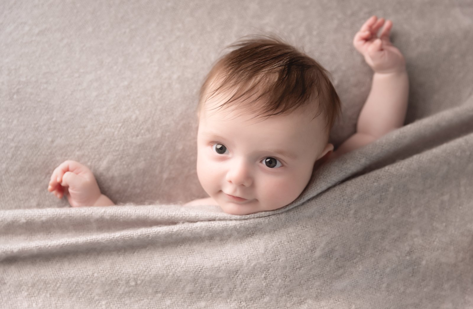 4 month old baby boy wrapped in grey for baby photos