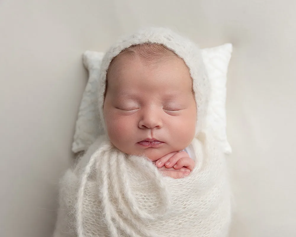Newborn with bonnet by Somerset newborn photographer Newborn with bonnet and wool wrap in white