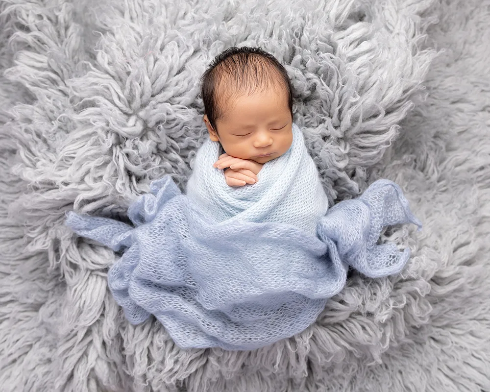 Sharon-Lewis-Photography-baby-and-newborns-Somerset Baby boy wrapped in blue on a blue rug